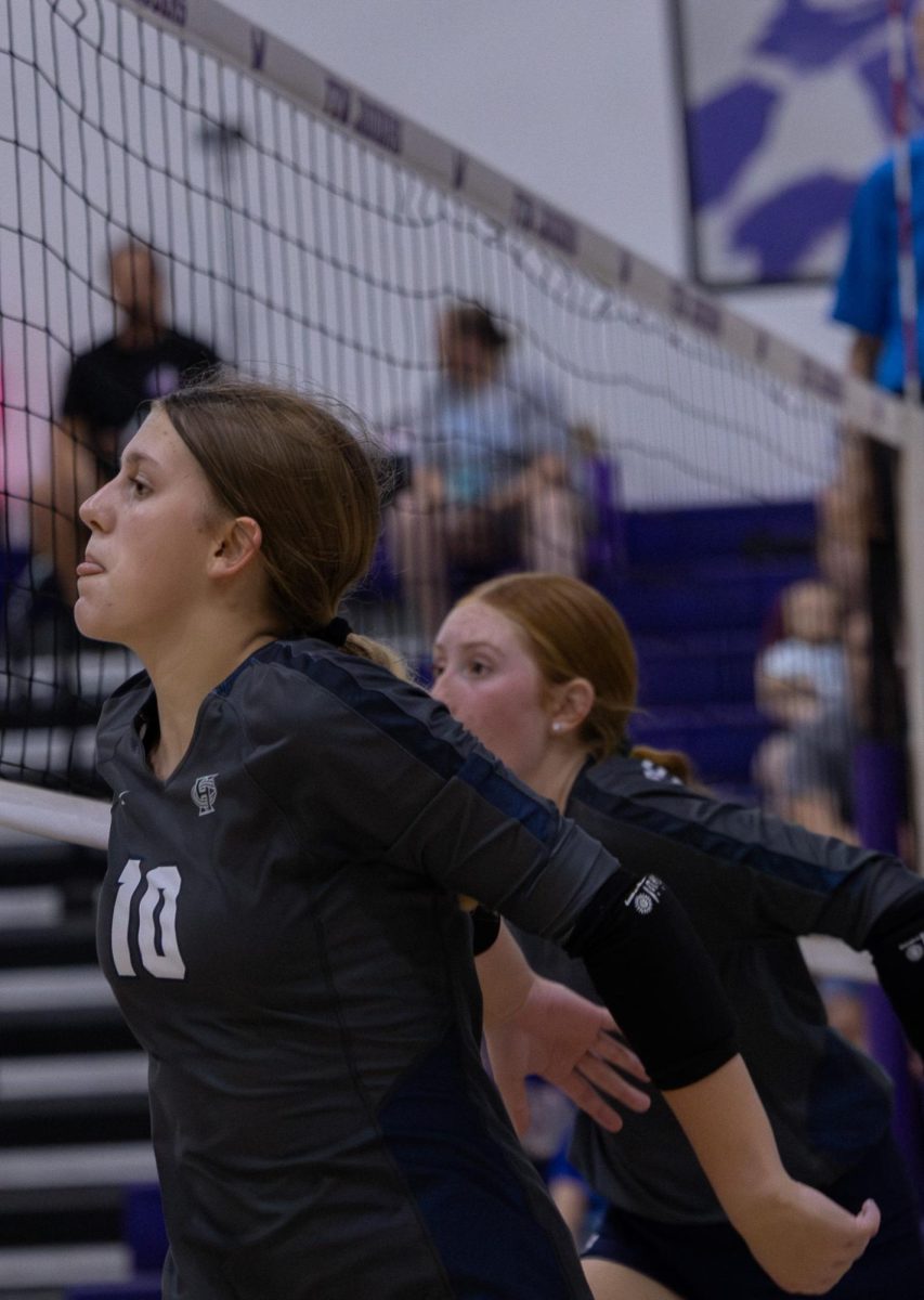 Freshmen Claire Kruczyk and freshman Belia Hutchison prepare to jump up and block the ball from the opposing team. Working together, they blocked the ball from entering their side of the court.