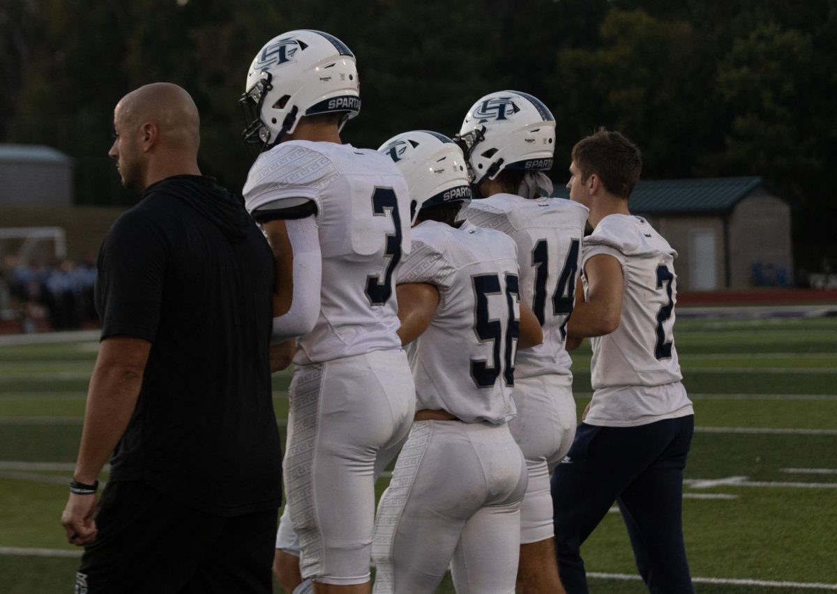 Alongside sophomore Jack Brown, head Coach Malach Radigan links arms and starts to walk up to the center of the field to greet the other team and talk to the officials for the night. As they walk up they stay locked in and get in the right mind set. 