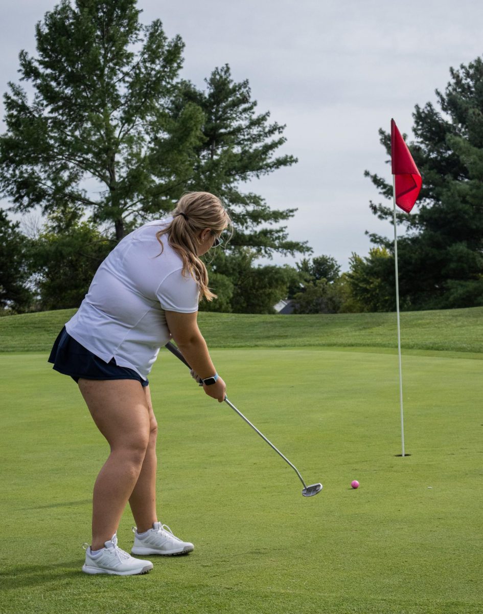 Junior Kennedy Burton watches her ball after she putts. It is important for golfers to stay quiet and focused while putting on the green.