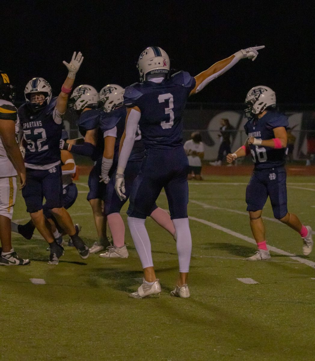 As he looks at his teammate, sophomore Jack Brown points down the line as the ref makes a decision on the next play. Brown was ecstatic with the call made and shows it through his actions.