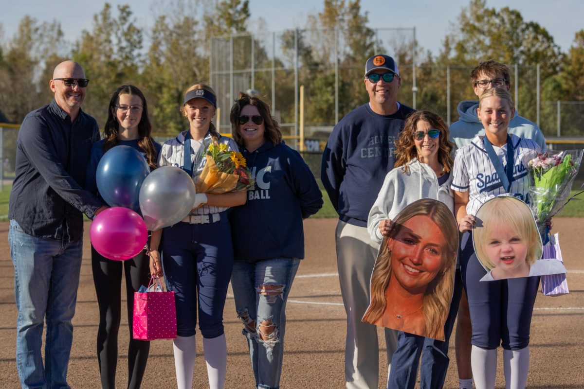 Seniors Maggie Meyer and Landry Harris pose with their families during the ceremony. The girls were given gifts by their families and teammates congratulating them on their final year on the team.   