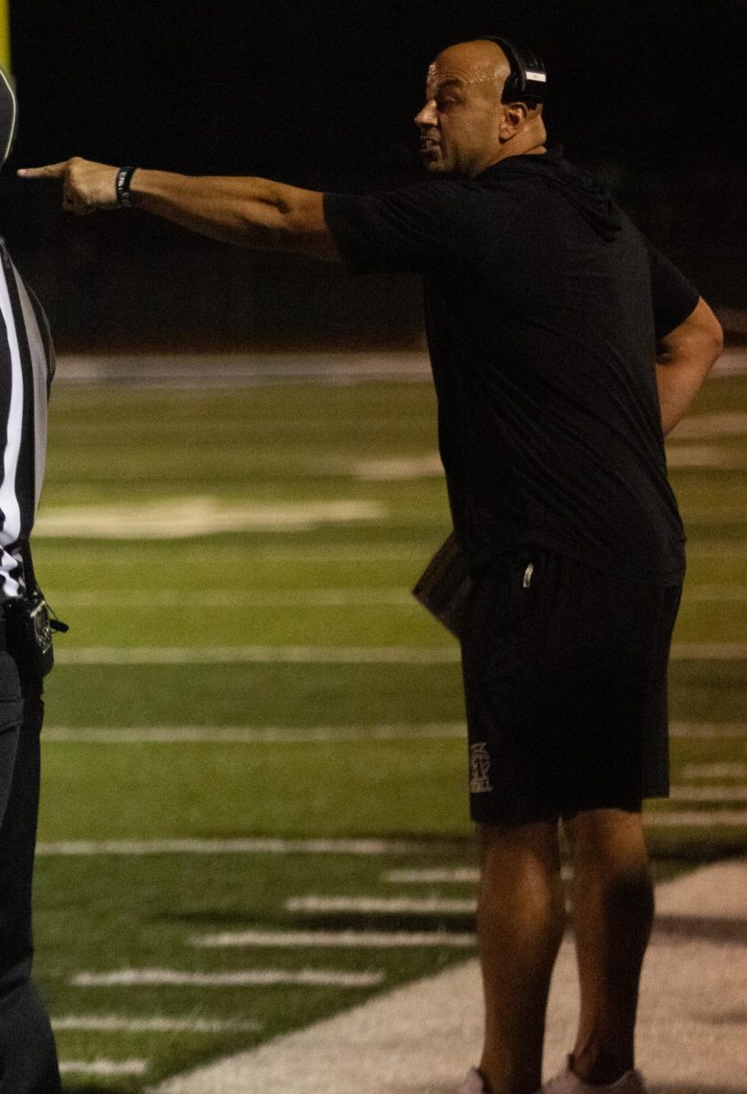 Head coach Malach Radigan stands on the edge of the sidelines watching his boys play. Radigan and the team have hand signals created to determine what play to use, without letting the other team know their plan.
