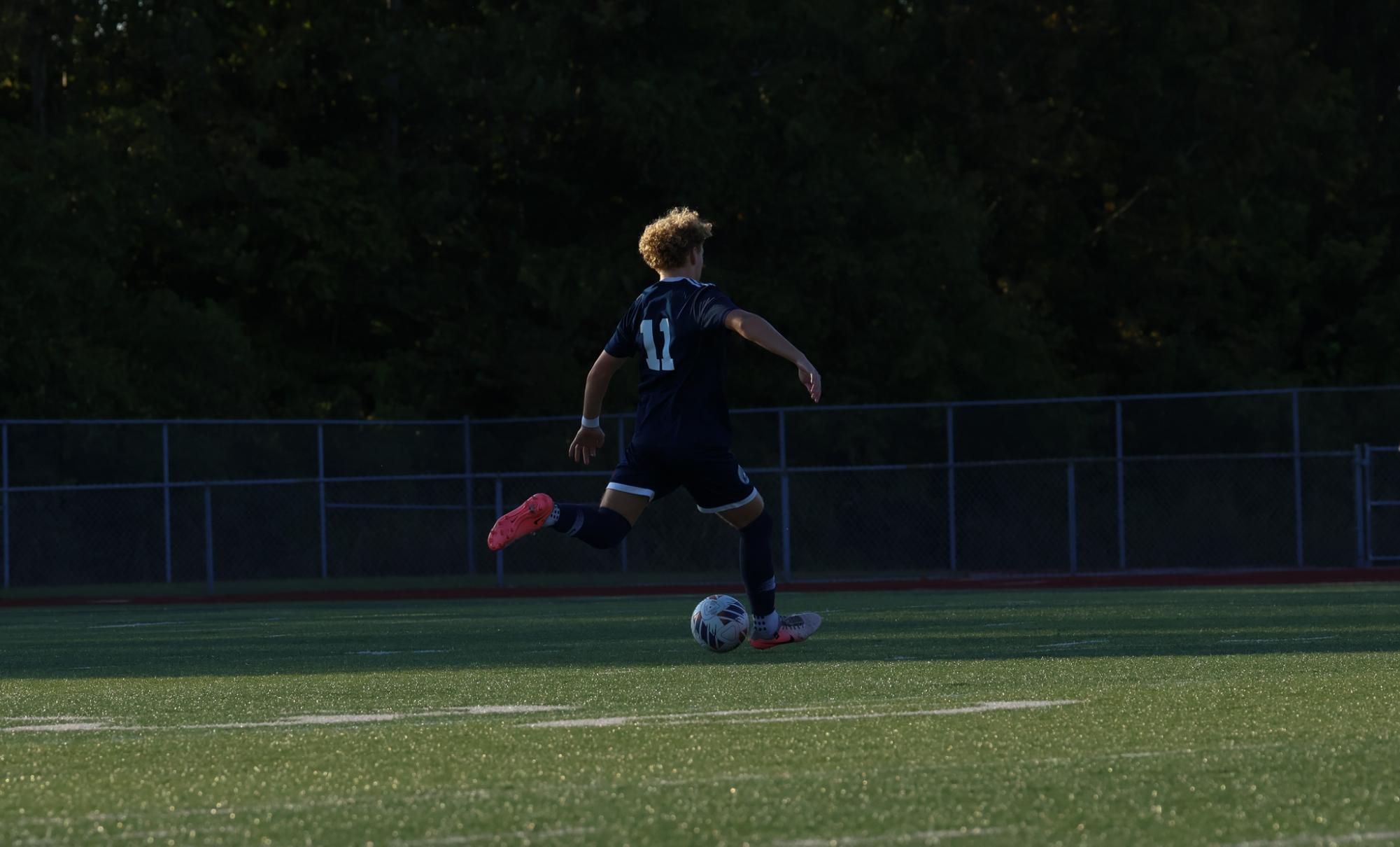 In a chase to the ball sophomore Chase Radeke prepares to strike it. His hustle got him to the ball before the other team.