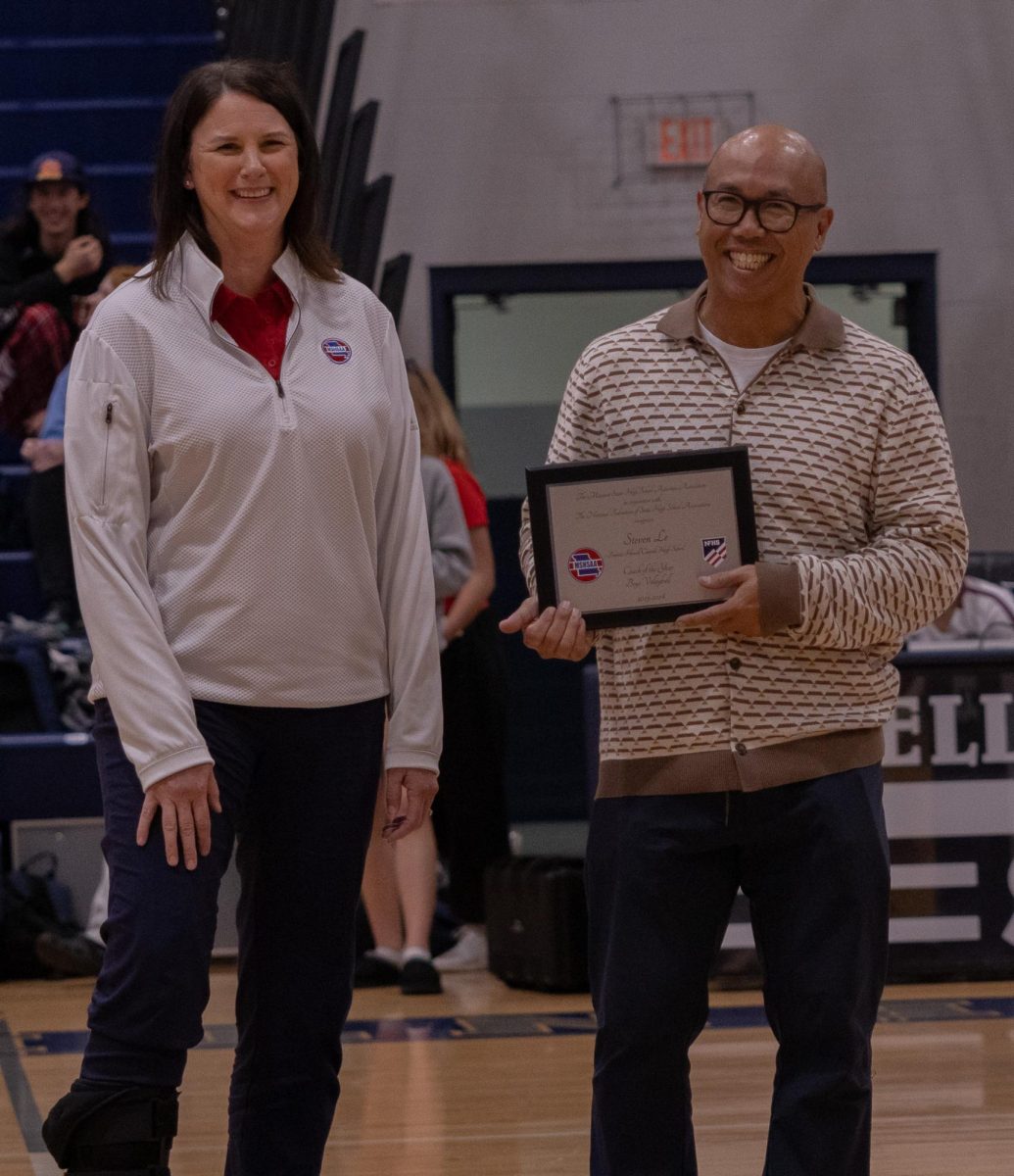 Award in hand, boys volleyball Coach Steven Le smiles as he receives the title of MSHAA Coach of the Year for the 2023 - 2024 season. Last year Le coached the varsity boys volleyball team to the state championships where they won second place in the finals.