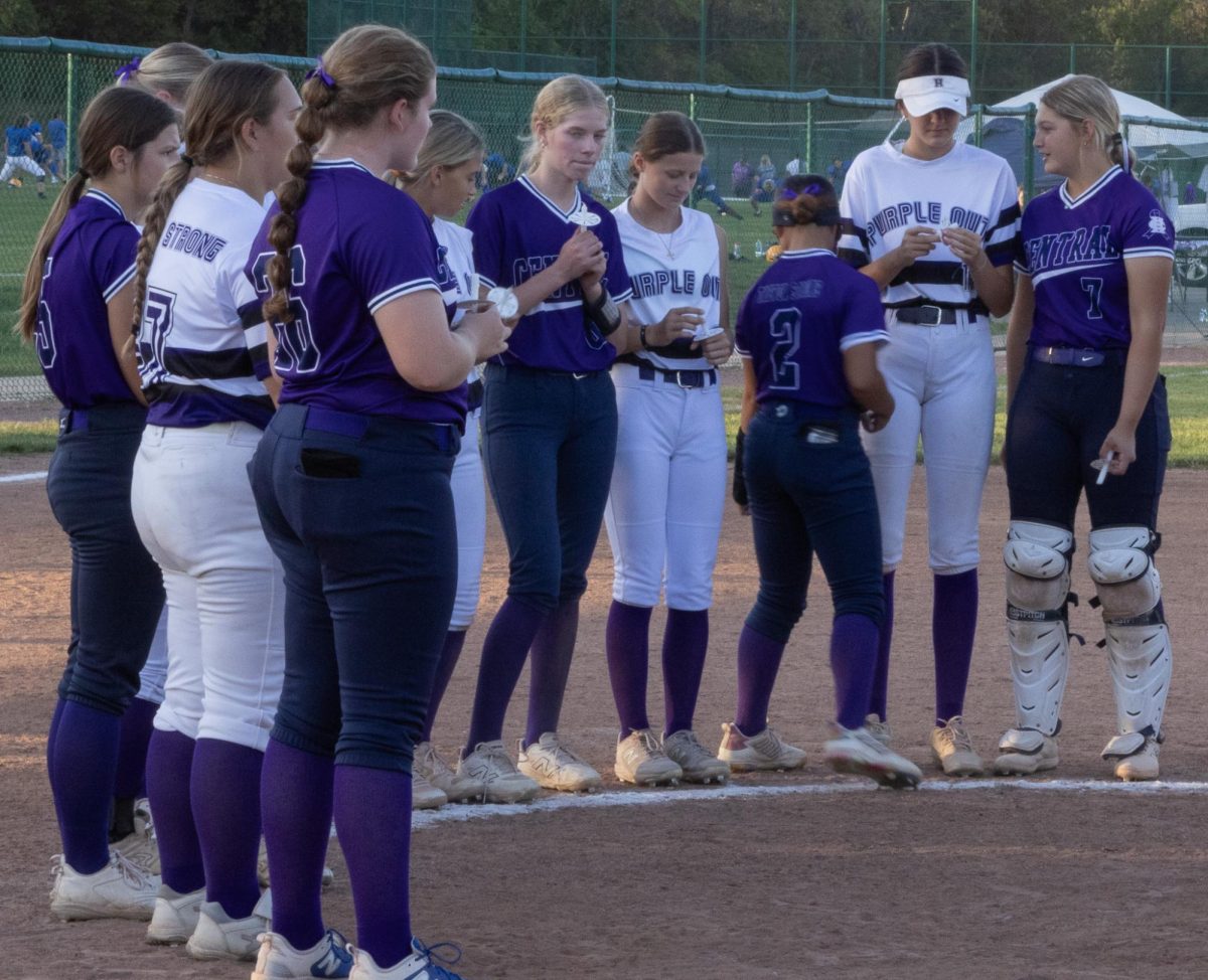 Spartans and Vikings alike form a circle around the pitcher's mound as they light candles in honor of Trevor Joerling. The 2024 purple out game was the tenth memorial game since Trevor died.