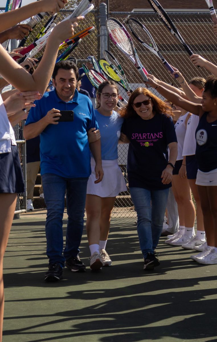 Nadia Manushev smiles as she walks through the tunnel with her parents. Players, coaches, and family gathered around to celebrate her and her other senior teammates.
