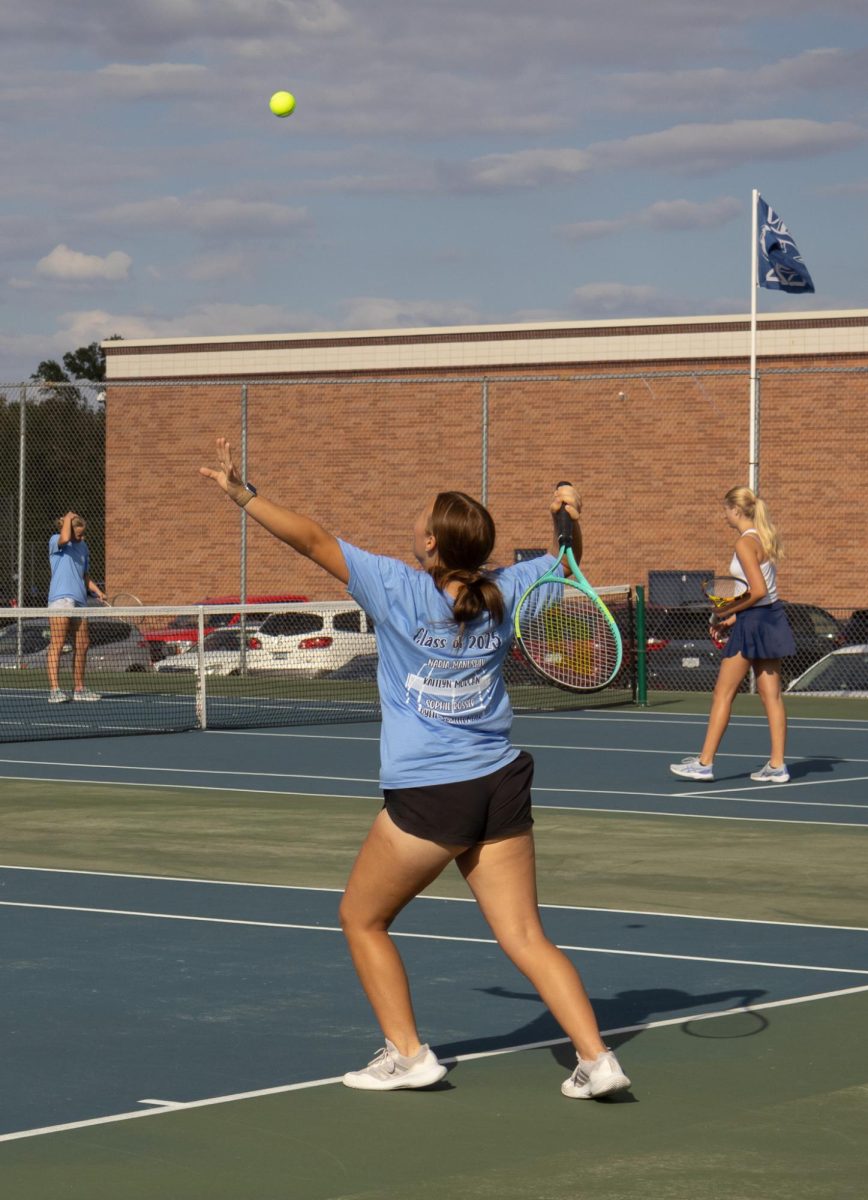 Senior Kaitlyn Morgan tosses the ball for a serve across the net.  Morgan and her doubles teammate fought hard throughout their whole senior night match.