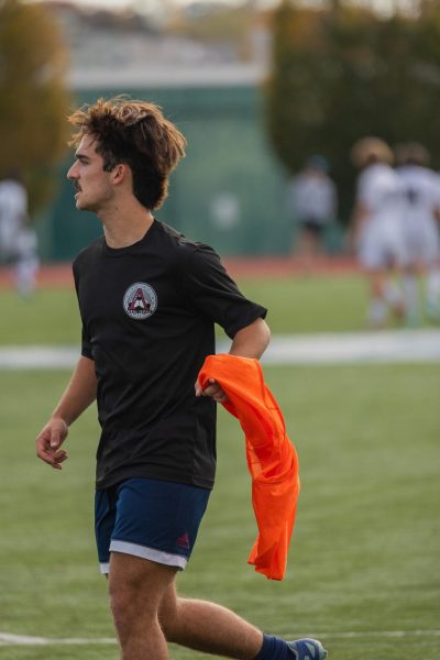 Junior Eddie Harton jogs off the field with the bright penny in his hand, Harton attempts to catch his breath before going back out on the field to continue to warm up. 
