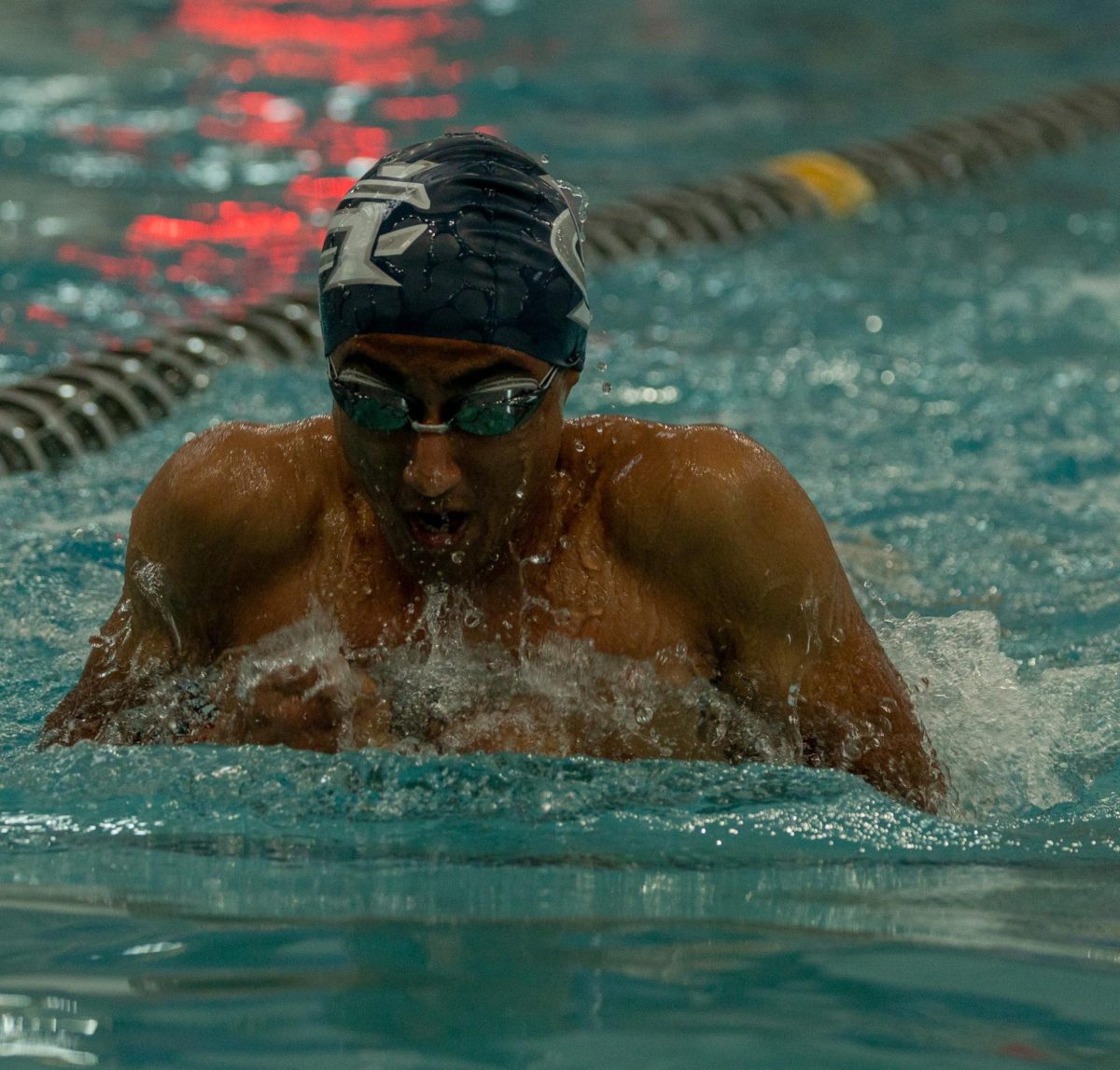 Aadit Mehta swims breaststroke during his individual event, taking long breaths in between each stroke. For breaststroke, the swimmers keep their chest and torso from moving in order to move quicker. 