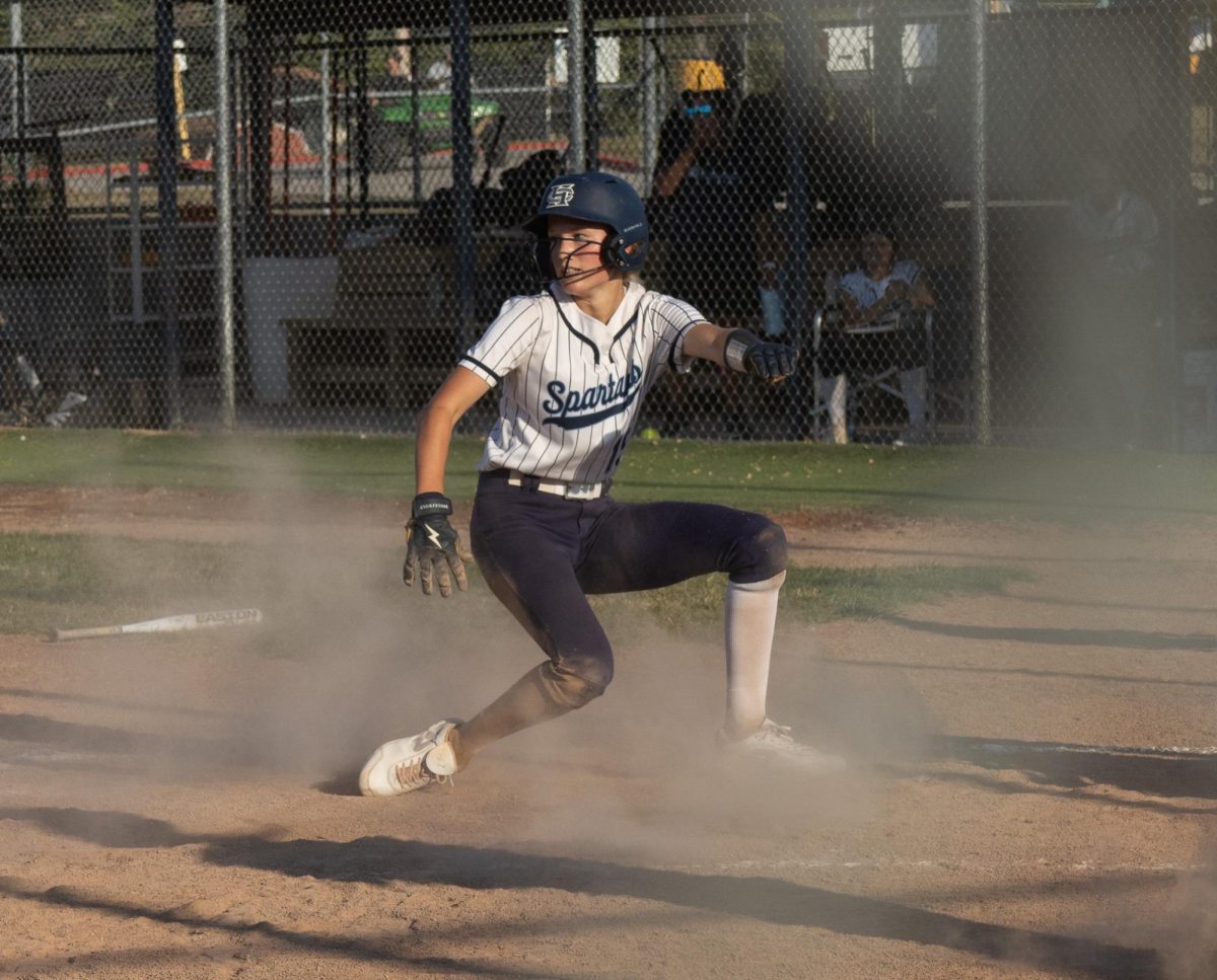 Junior Alex Meyer slides to home base, watching the ball the whole time. She successfully scored a run for the team.