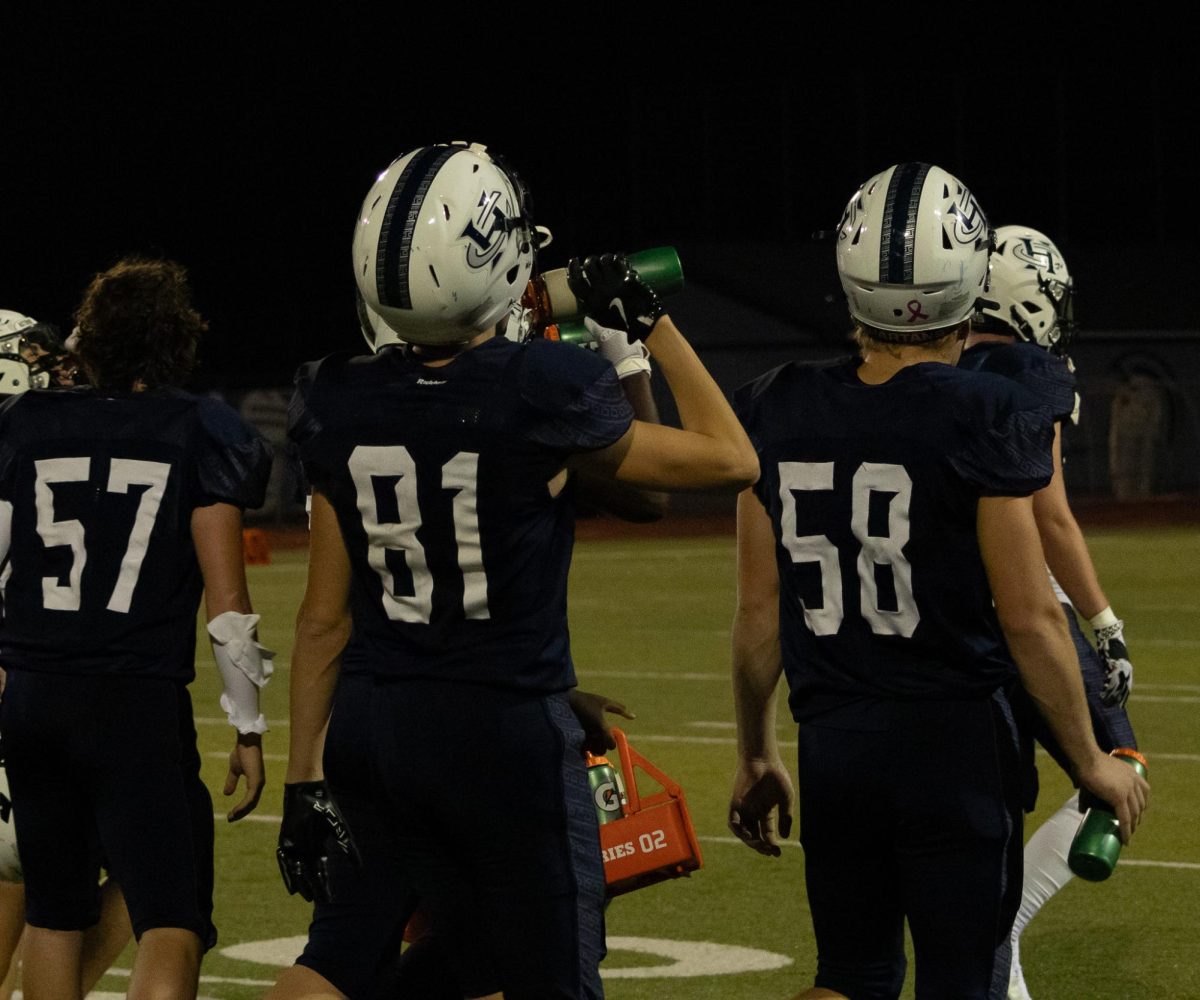 Junior Aiden Bellanger receives a water bottle from the water boy and takes a moment to hydrate before halftime ends. It is very important to stay hydrated during any physical activity and it is the water boy’s responsibility to fill and carry bottles to have on hand for all the players.