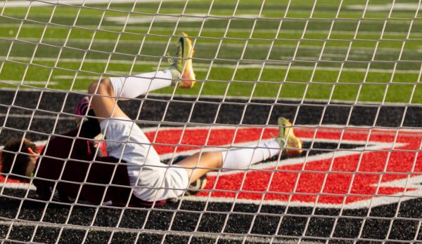 Under the goalposts, freshman Jack Morris lays with his legs up, preparing to catch the oncoming ball. Morris will often send himself to the ground to block a shot. 
