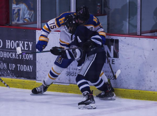 Senior Jacob Haas slams his opponent into the boards, attempting to win the puck back. While fighting for the puck, the play got out of hand which resulted in a fight between the two players. 