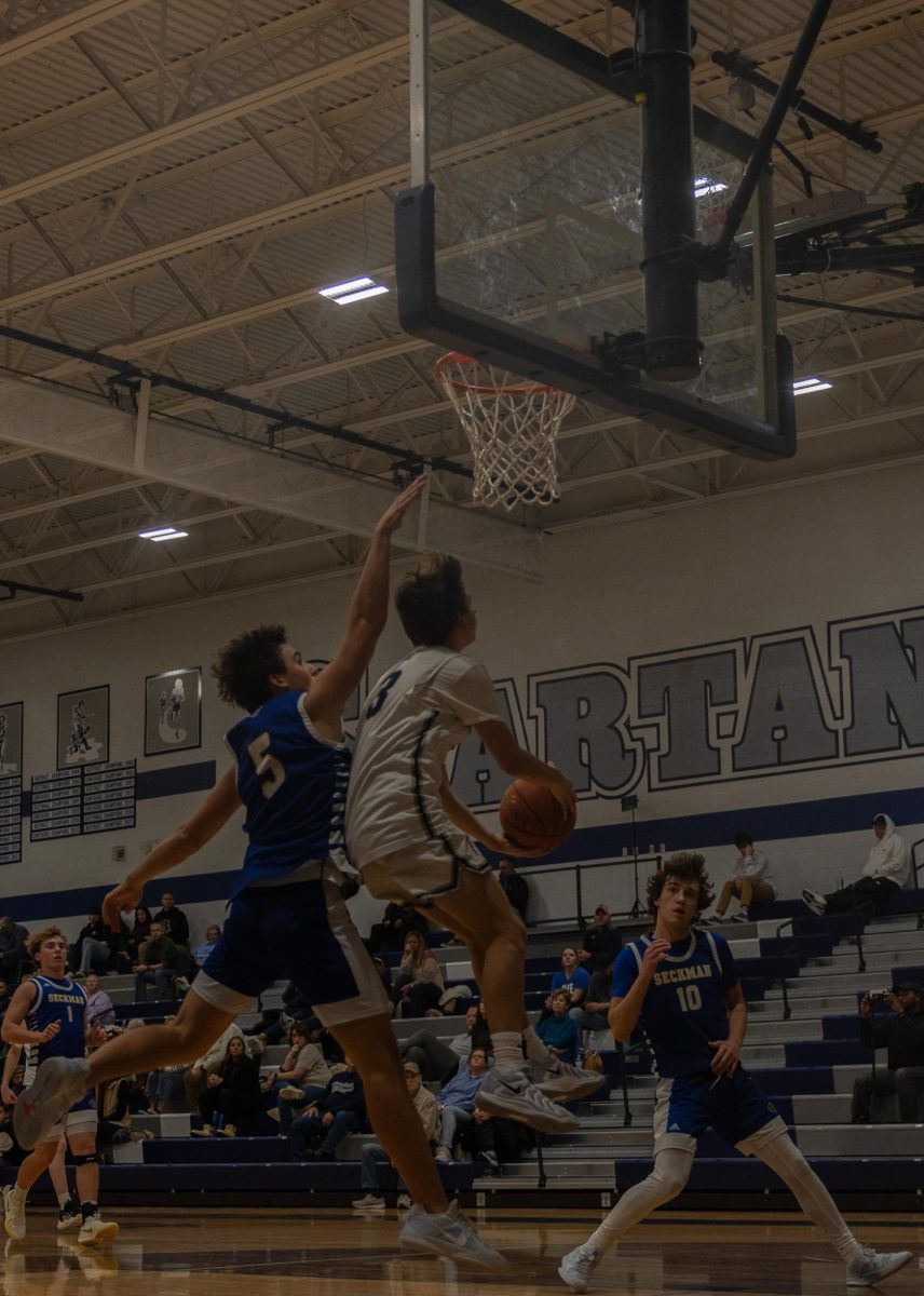 Freshman Tyler O’Brien goes up to the basket with a layup.  O’Brien made the shot even though he was being blocked by a Seckman player.