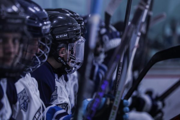 The team sits on the bench during a break between shifts, exhausted from the game. Sophomore Matthew Grishman turned his head to the side, as he watched the game progress. 