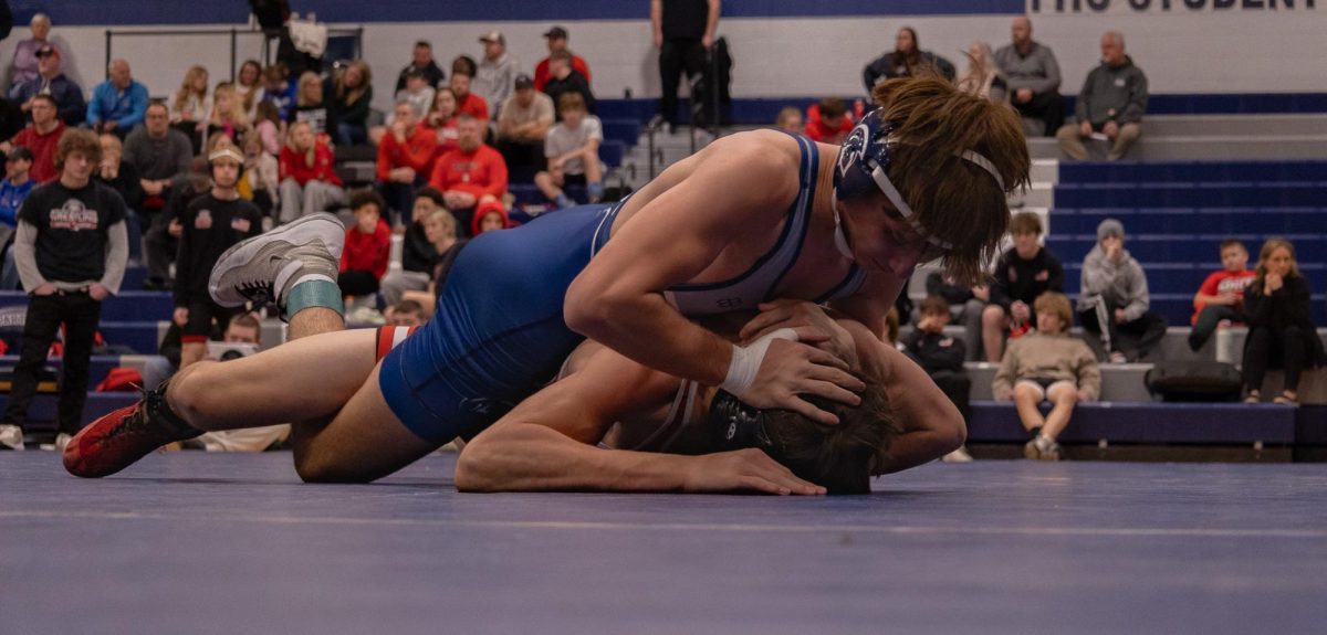 Shoving his opponent's head into the mat, Chase Gray waits for his opponent to make a move to try and get out of the hold. Gray slides his arm under his opponent's arm and to the back of his head to try and work a move.  