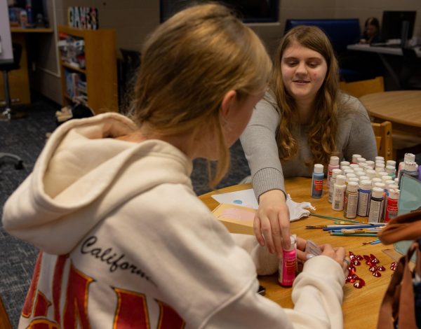 Reaching for the paint, sophomore Reagan Bland and her group begin to design the box for their cards. The boxes were intended to express creativity, allowing students to personalize their quiz games.
