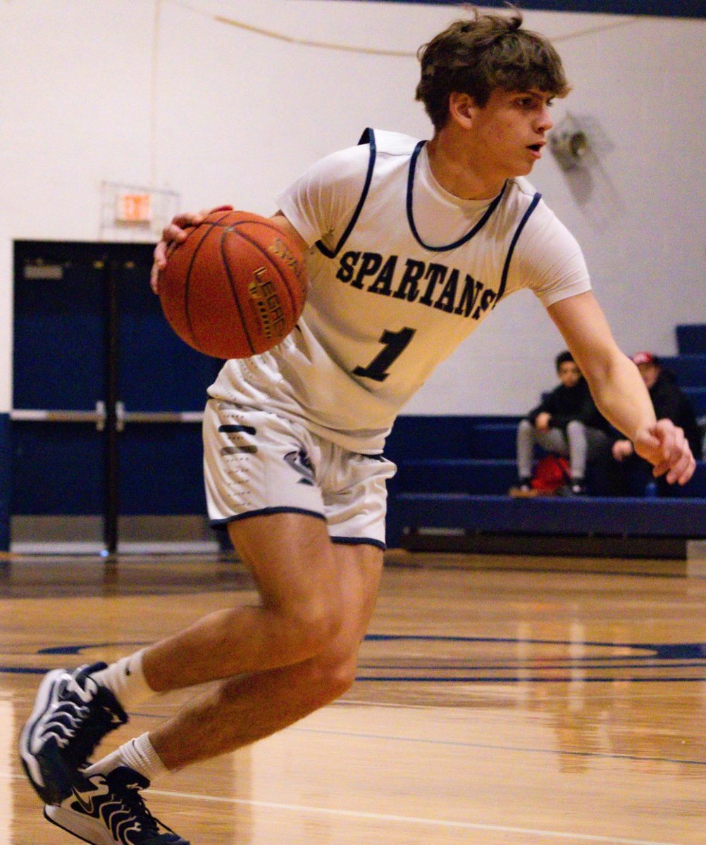 Freshman Will Schuster dribbles down the court. Schuster swung the ball to an open teammate to start the first possession of the game.