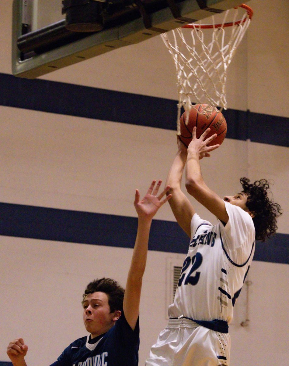 Freshman CJ Hunter shoots a fast-break layup over his defender. After receiving a long pass from his teammate, Hunter immediately brought the ball up to shoot.