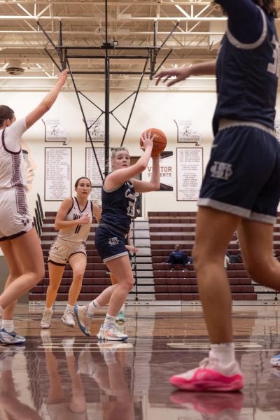 Senior Addie Henderson holds the ball on the freethrow line as she looks at her teammate Jayla Robinson who is below the basket. She looked for a teammate closer to the basket in order to get a better opportunity to score.