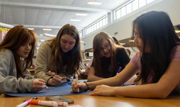 Freshman Asher Larabee, Gretchen Olson, Lily Placht, and Joanna Chiu send their appreciation in the large card addressed to one guidance counselor. Each table at the social had a card for a different guidance counselor, after writing their letters students traveled from table to table to share their appreciation for the help they received throughout the years. 