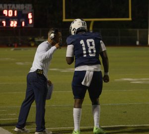 In between plays, junior Jaylen Blue runs back to the sidelines to listen to the new play call. Coach Devon Thomas spoke to Blue about the team's position and their plans.