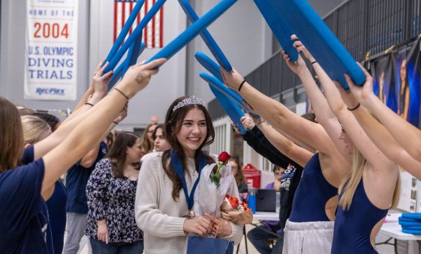 Celebrating her time on the varsity swim team, co-captain Caroline Kraft walks through the tunnel of boards created by her underclassmen teammates. This was Kraft’s third year on the team and first-year leading as a captain alongside her close friend Regina Avila.  