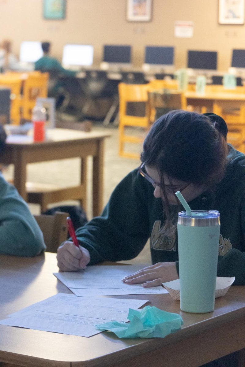 A student concentrates on brainstorming ideas for improving the mission statement. The students spent the entirety of seminar working together to come up with something new.