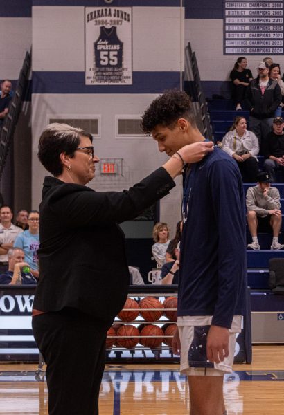 Principal Suzanne Leake smiles as she puts a medal around senior Ethan LeFlore’s neck. Dr. Leake later hugged LeFlore for his accomplishments and commitment to the basketball program.