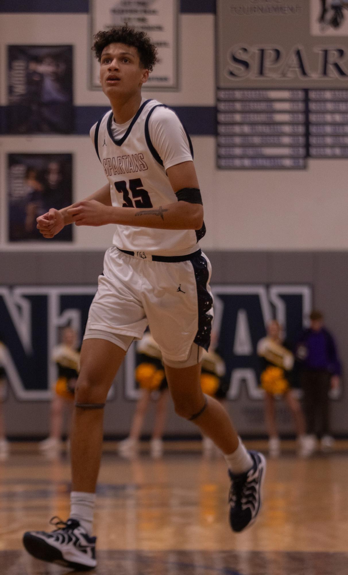 While running over to the basket, Ethan LeFlore looks to the top and watches the basketball. LeFlore looked to see if he needed to guard an opposing player or stay active and moving to get open for a potential pass from another teammate.