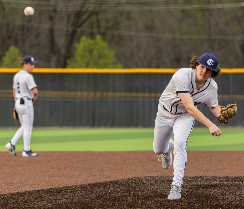 Senior Thomas Masterson watches the ball after he pitches it during his warm up before the inning starts. Pitchers have to warm up before each inning to keep their arm fresh for the rest of the time they pitch. 
