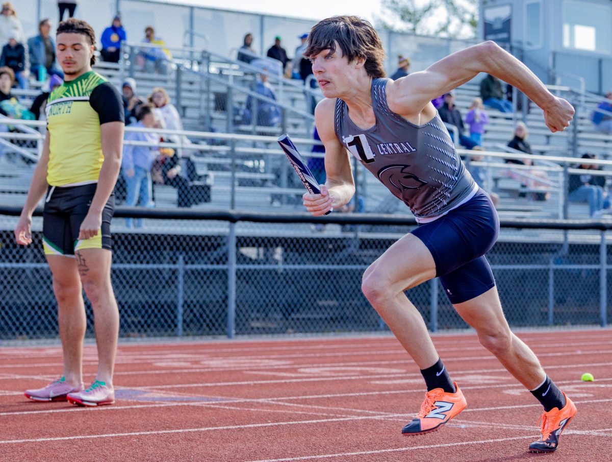Beginning the first boys' relay of the day, sophomore Will Bradley blasts off the block, trying to get ahead of the other racers. Bradley started in lane one and, because lane one is shorter than the other lanes, started further back than the other racers. 