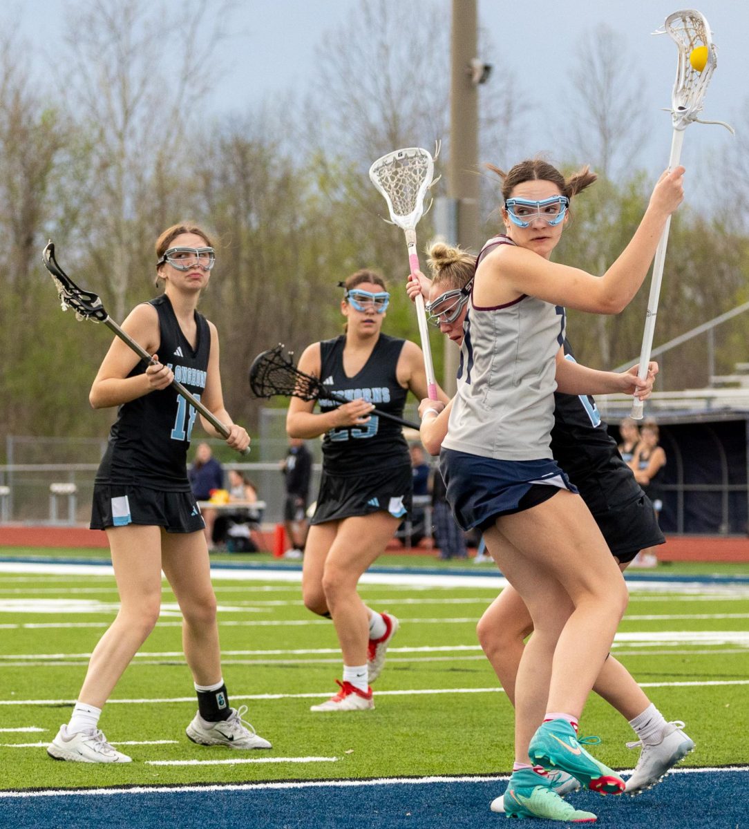 Senior Mckenzie Schweitzer prepares to pass the ball to one of her teammates. She glanced behind her to determine the right positioning for the play. 