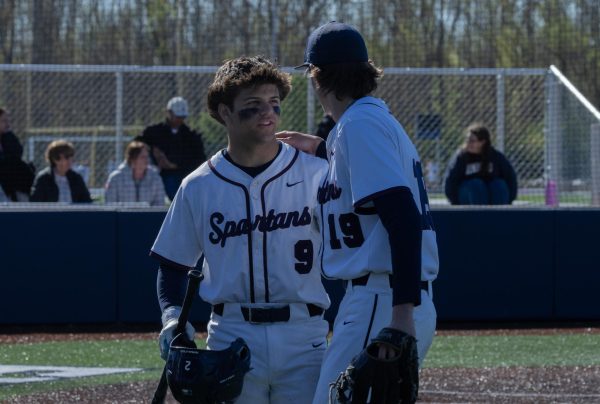 Before Drew Wyss goes to hand his stuff to another teammate coming off the field he chats with junior Brayden Jones after coming off of the bump. Wyss then handed his teammates his helmet and bat so he wouldn't come back into the crowded dugout.
