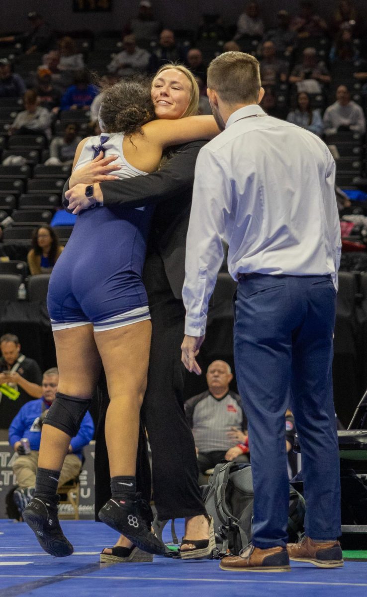 Senior Makenzie Solis runs over to Coach Kennedy Eggering after winning her blood round match. Solis then went on to wrestle in the third place match.
