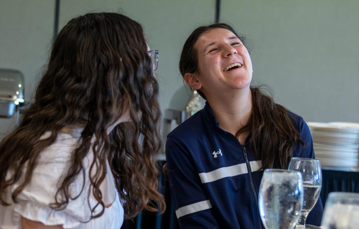 Talking with senior Nadia Manushev, senior Sydney Belter throws her head back laughing while waiting for lunch to be served. Each student went through a buffet line, being offered salad, steamed vegetables, pasta and chicken. 