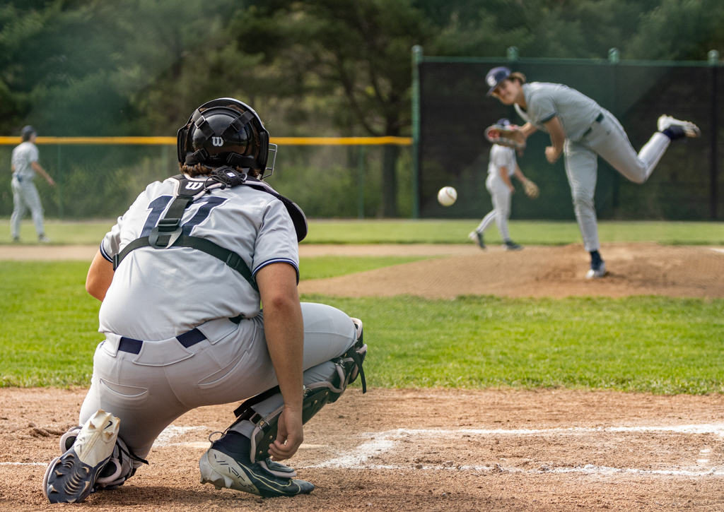Senior Owen Meyer squats as he catches the ball thrown by pitcher sophomore Lucas Williams. Before each inning starts the pitcher and catcher are allowed a few practice throws to get both players ready. 