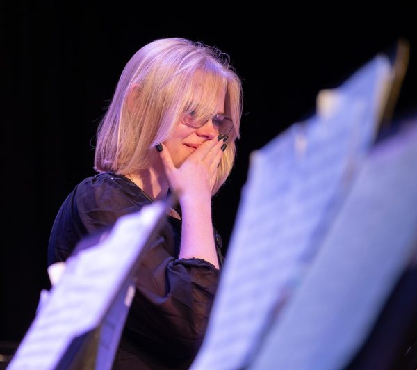 Standing up after hearing her name called by the band directors, senior Tia Harlow holds her hand to her mouth as she softly cries. Harlow was a drum major during marching season and was awarded the music departmental award at Senior Awards Night. 