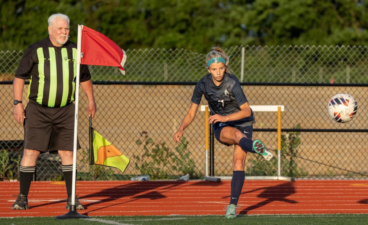 Putting the ball back in play, Riley Henderson kicks the ball with the side of her foot. Henderson has been a part of the soccer team for the past four years. 