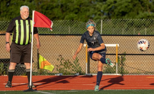 Putting the ball back in play, Riley Henderson kicks the ball with the side of her foot. Henderson has been a part of the soccer team for the past four years. 