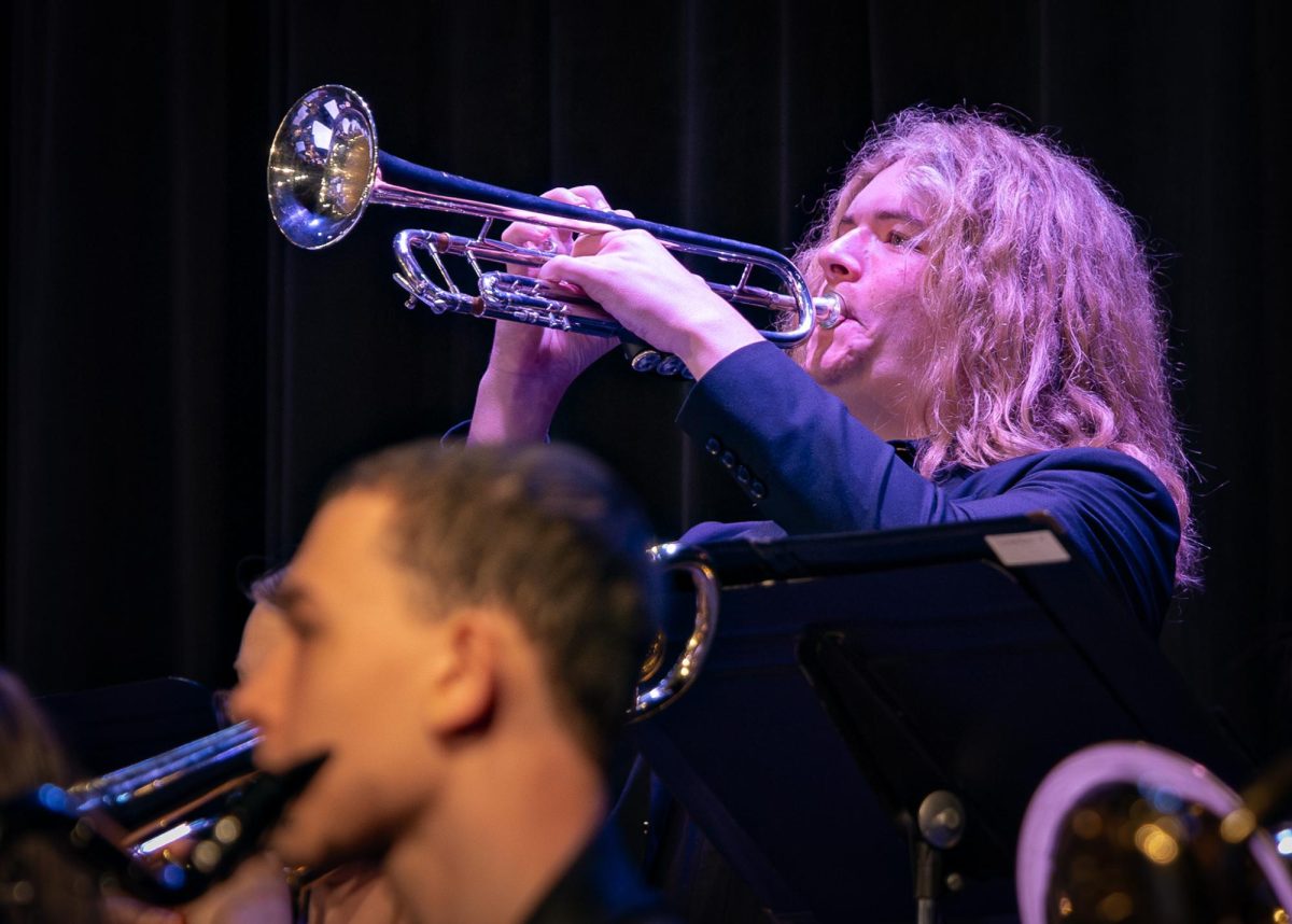 Holding his trumpet up, freshman Luke Bounds blows into the instrument. While he played along with the band he had to face his instrument upwards to help project the sound during the jazz concert on May 12.