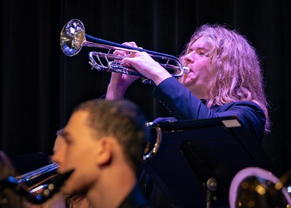 Holding his trumpet up, freshman Luke Bounds blows into the instrument. While he played along with the band he had to face his instrument upwards to help project the sound during the jazz concert on May 12.