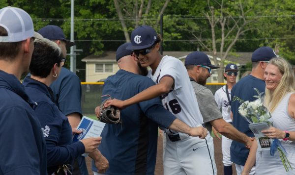 While walking down the line of coaches to shake everyone's hand, senior Ethan LeFlore hugs his coach. LeFlore then went on to shake everyone else's hand, and he then received his award for senior night. 