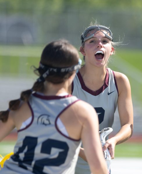 During the starting lineup call, sophomore Addison Holtgrewe cheers on her teammate as she runs through the line. Holtgrewe jumped in the air as she hyped up all of her teammates.