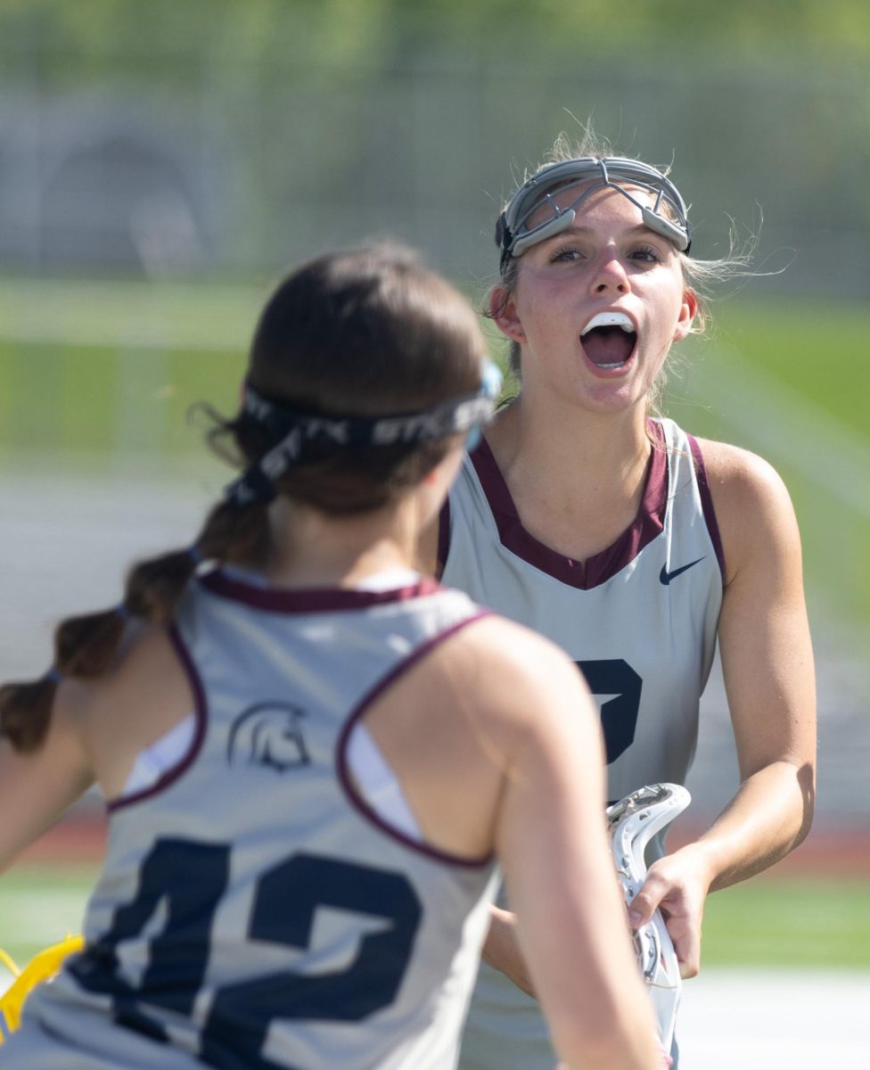 During the starting lineup call, sophomore Addison Holtgrewe cheers on her teammate as she runs through the line. Holtgrewe jumped in the air as she hyped up all of her teammates.