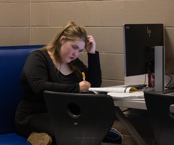 Alyssa Keen looks over her work while listening to music. As the end of the school year approaches, the workload increases for many. 