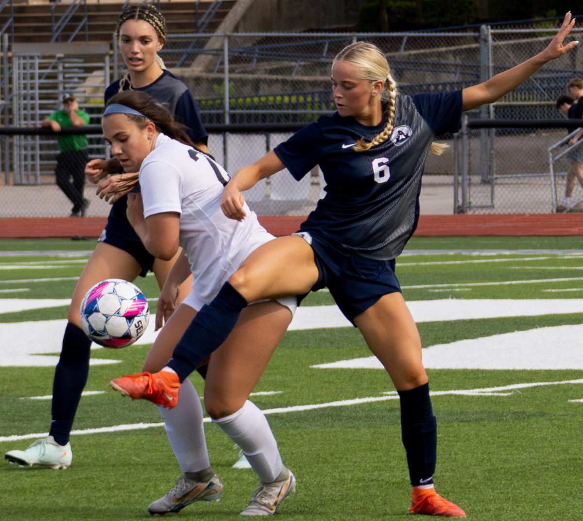 Keeping balance on one foot, senior Julia Peters stretches the other leg across an opposing player's body, blocking the ball from the Knight's possession. The Francis Howell North players shot the ball around the field until Peters' block brought the ball into the Spartans' hands.
