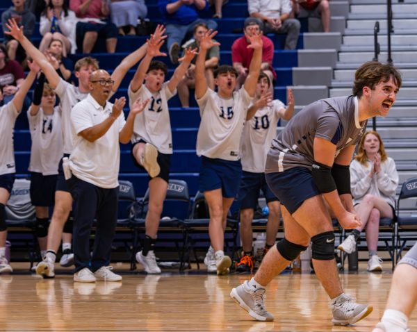 After successfully helping earn a point for the Spartans, junior Braden Harton screams in excitement. Many supportive players, managers and coaches from the bench helped to cheer on the boys between sets to keep morale high.