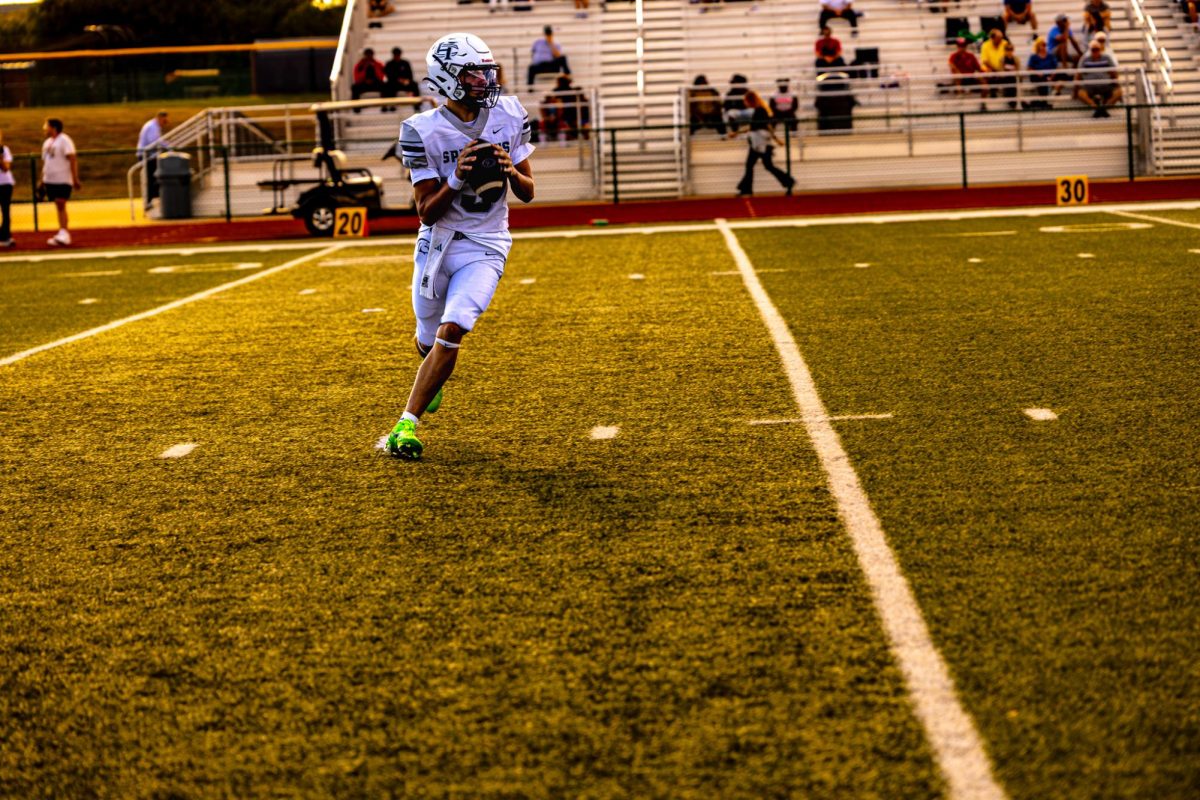 Freshman Sam Aholt rolls out of the pocket to escape the pressure. What a game by Aholt, with rushing and throwing two touchdowns. 

