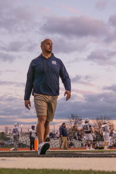 Walking around the field on Oct 30, Head Coach Malich Radigan goes over to talk to the refs before the game starts. Radigan then walks over to his players to get them excited for the game.